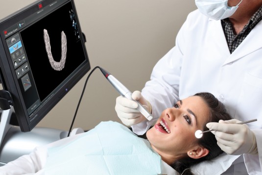 woman in chair receiving dental impressions | Andrew W. Skorobatckyj