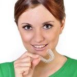 woman in green shirt holding retainer | Dr. Andy