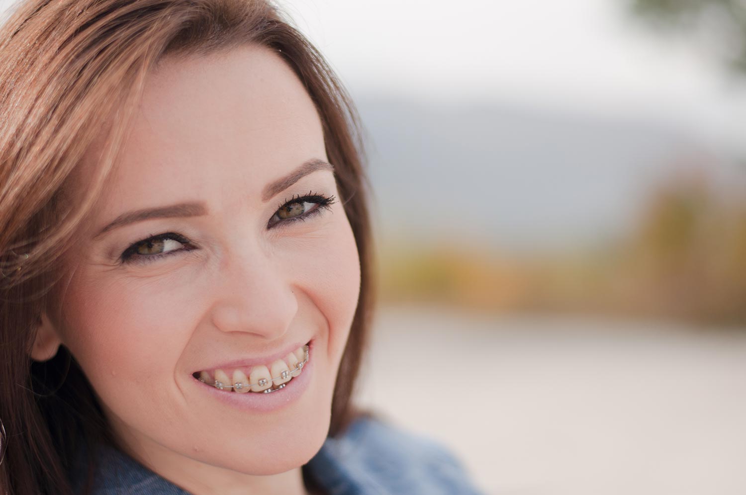 Young woman smiling with metal braces on her teeth