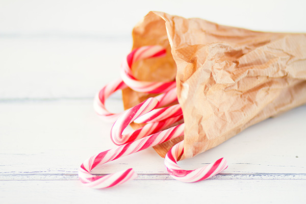 Peppermint candy canes in a bag resting on a table.