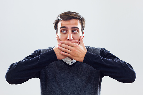 A man holding his hands over his mouth.