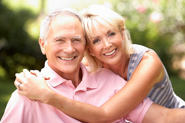 A senior couple using Invisalign for seniors to improve the alignment of their teeth